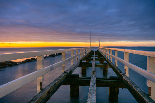 Pier without floor in a colorful orange sunset at the baltic sea