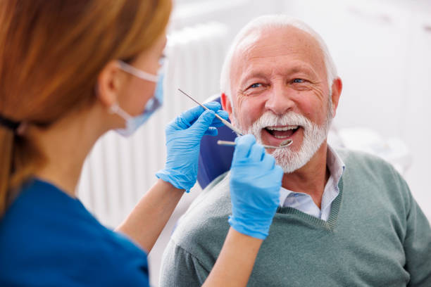 Doctor checking up patient at dentist office Doctor checking up patient's teeth at dentist office; senior man at dental checkup dentists office stock pictures, royalty-free photos & images