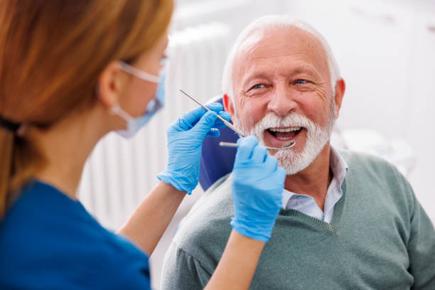 doctor checking up patient at dentist office - dentists chair fotos imagens e fotografias de stock