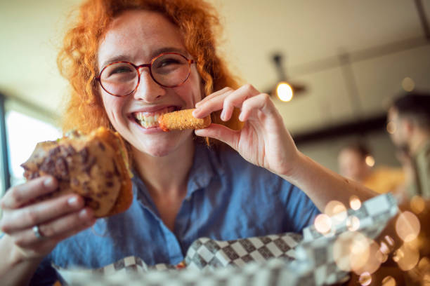 istock During the lunch break, the student eats her favorite hamburger. 1397217996