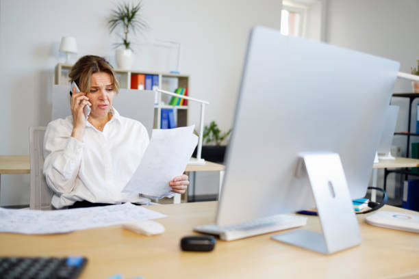 istock Woman accountant indignantly looks at documents and talks on the smartphone 1397223524
