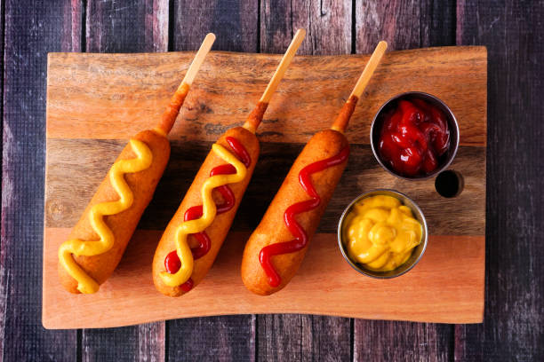istock Corn dogs with different toppings on a wooden platter 1397226779