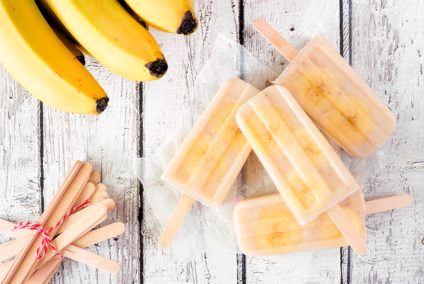 istock Healthy banana yogurt popsicle table scene over rustic white wood 1397226810