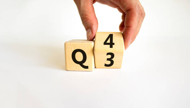 From 3rd to 4th quarter symbol. Businessman turns a wooden cube and changes words 'Q3' to 'Q4'. Beautiful white table, white background. Business, happy 4th quarter Q4 concept, copy space. stock photo
