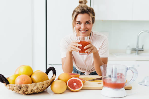 istock Woman drinking freshly squeezed homemade grapefruit juice in white kitchen 1397230441