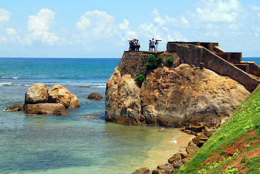 Galle: Flag Rock - de Visser's Hoek / Fisher's Hook rock promontory - Galle Fort - Old Town - UNESCO World Heritage Site. The fort stands on a flat, rocky outcrop surrounded by cliffs on the southwest corner of Ceylon, connected to the rest of the island only by a narrow strip of land. The Portuguese built a wall here in the 16th century with three bastions and two gates that closed off the peninsula. Behind the wall was a town around a small semicircular natural harbor with a fortress called Fortaleza Santa Cruz. Later it became a fortified trading post of the Dutch East India Company.