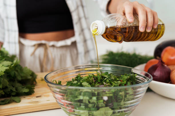 istock Female hand adding extra virgin olive oil to vegetarian salad 1397231474