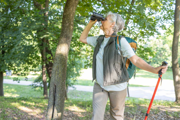 istock Older woman using binoculars on a hike in forest 1397232438