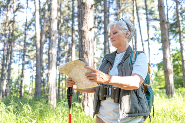 istock Serious mature female hiker looking at touristic map 1397232450