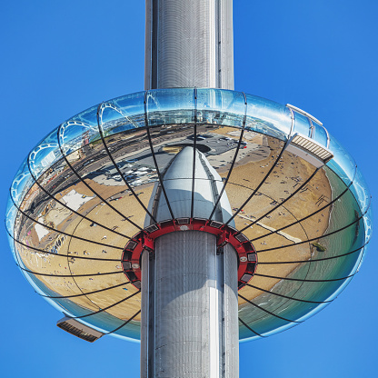 Brighton, UK - Jun 09, 2021: the reflective people-carrying pod of the British Airways i360 tower alongside a dazzling blue summer sky in Brighton, UK. The tower elevates people to stunning views of the famous British seaside town.