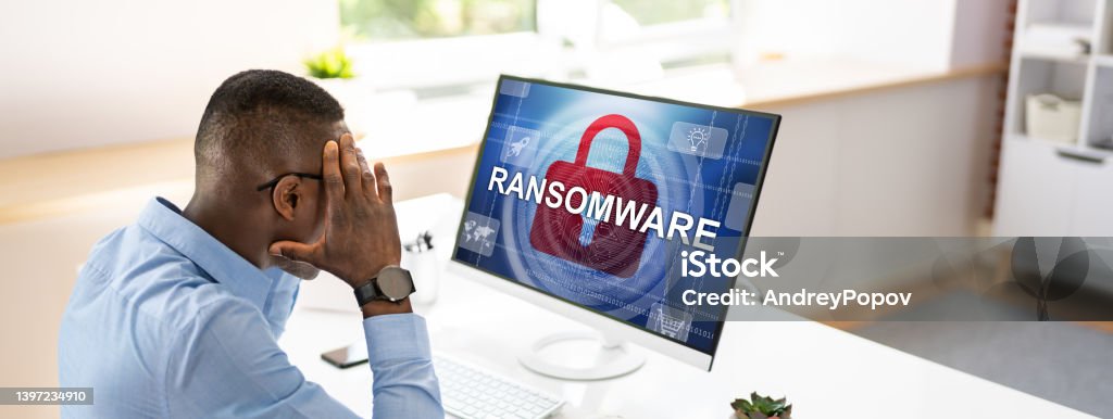 Person Looking At Computer Screen Worried Businessman Looking At Computer With Ransomware Word On The Screen At The Workplace Ransomware Stock Photo