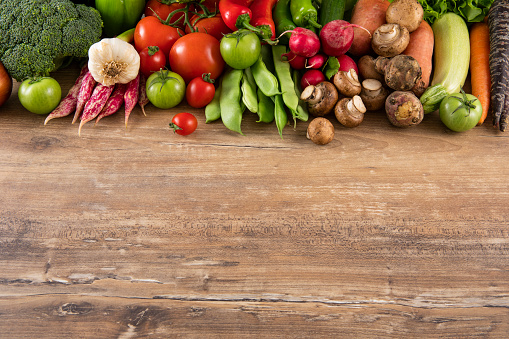 Fresh vegetables on brown wooden background with copy space