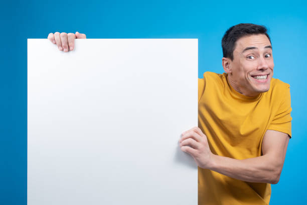 istock Excited man showing blank banner in studio 1397241580
