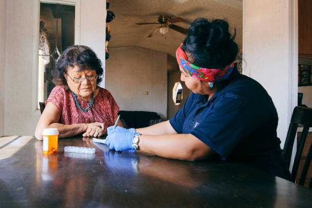 Senior Healthcare Assistance in a Home An Indigenous Navajo senior aged woman, receiving healthcare assistance in her home. indigenous north american culture photos stock pictures, royalty-free photos & images
