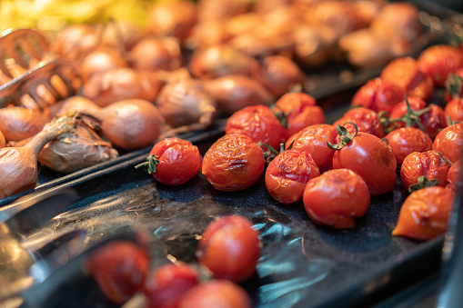 Heaps of roasted onions and cherry tomatoes on the buffet