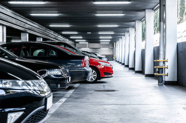 carro vermelho paked em garagem subterrânea com muitos veículos - building feature parking garage stationary built structure - fotografias e filmes do acervo