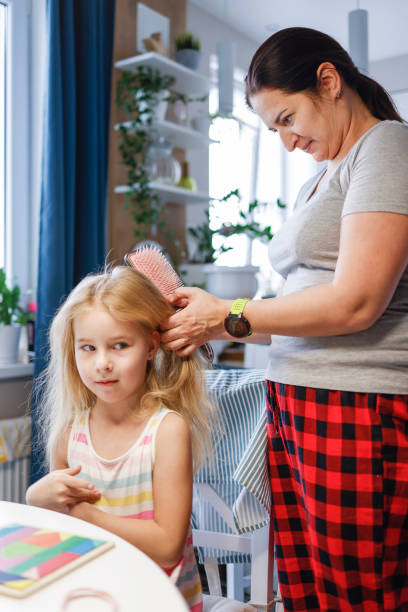 istock Hairdress at home: young mother making ponytails for her little daughter 1397252417