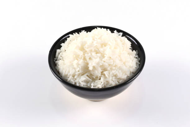riso in ciotola nera su sfondo bianco. - clipping path rice white rice basmati rice foto e immagini stock