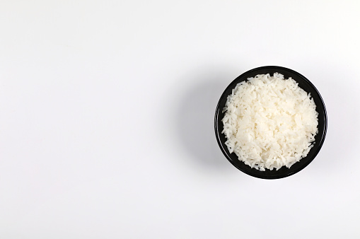 Rice in black bowl on white background top view have copy space.