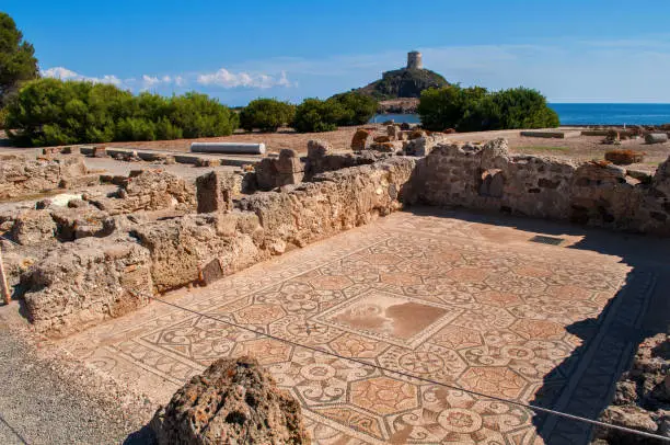 Uncovered excavations with an old tower in the background near the town of Nora on the island of Sardinia