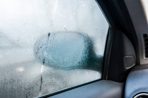 finestrino dell'auto fumante in una giornata autunnale piovosa / nebbiosa. concetto di problema di guida di sicurezza - wet dew drop steam foto e immagini stock