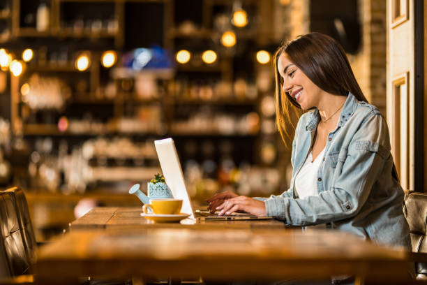 istock Happy young woman using laptop in a cafe. 1397259222