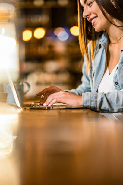 istock Happy young woman using laptop in a cafe. 1397259956