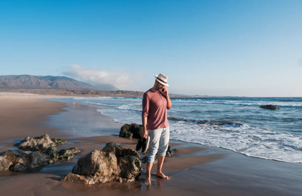 istock man talking on the cell phone on the beach at sunset 1397264616