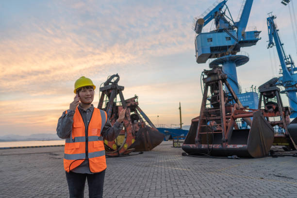 istock An Asian female engineer communicates with her mobile phone at the dusk dock 1397268537