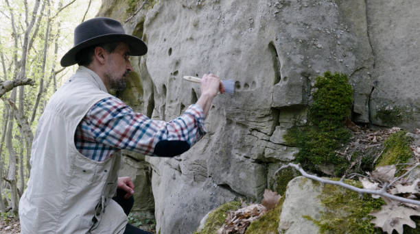 Archeologist working on the field. Exploring  petroglyphs in ancient rock dwellings and analysing the ancient drawings. paleontologist stock pictures, royalty-free photos & images