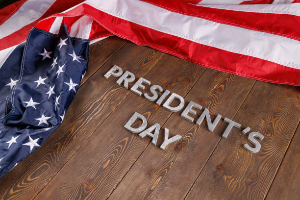 istock words presitdents day laid with silver letters on wooden surface near US flag 1397270664