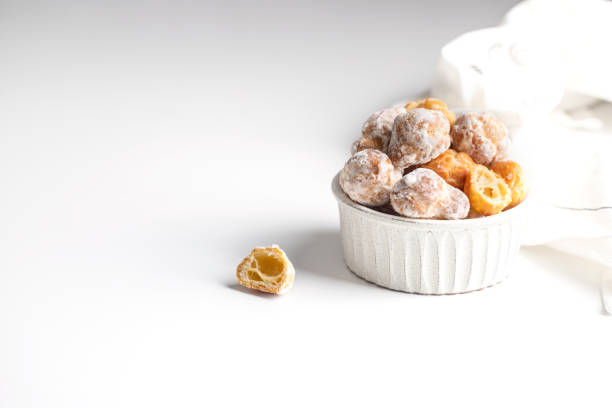 istock Bunuelos, Spanish small deep fried doughs in ceramic bowl on white background with napkin. 1397270692