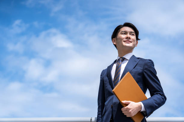 A businessman standing against the blue sky stock photo