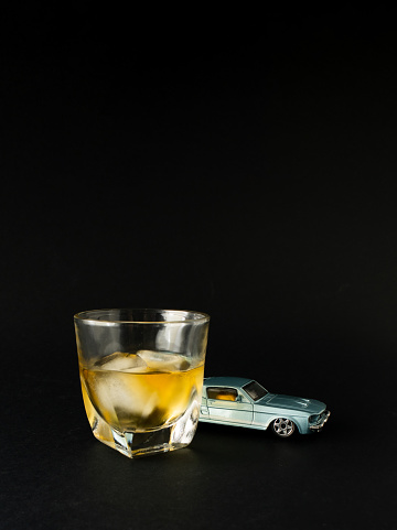 Old school classy composition, with blue oldtimer,  and glass of cold drink beverages. Classy, vintage concept on black background.