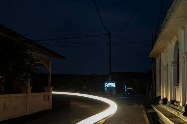 Galle, Sri Lanka March 13, 2022 A tuktuk taxi stands lit-up at night on a street in Galle Dutch Fort during an electricity blackout.