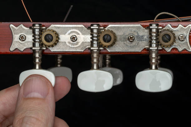 close up of a male hand tuning guitar pegs on headstock. - spanish culture audio imagens e fotografias de stock