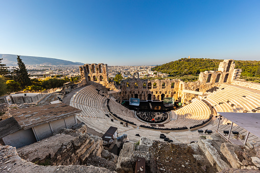 Athens, Greece - July 26, 2021: Odeon of Herodes Atticus, a steep-sloped theatre with a three-story stone front wall and a wooden roof. On the hills of Athens near the most famous citadel acropolis