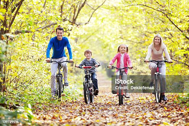 Family Riding Bikes Through Leaves Stock Photo - Download Image Now - 20-29 Years, 30-39 Years, Active Lifestyle