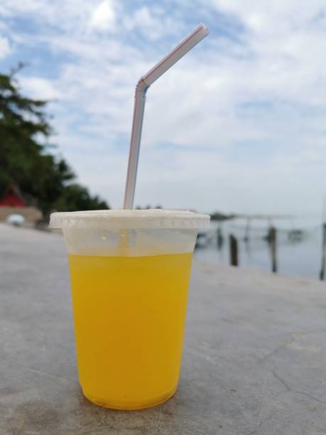 istock a glass of orange juice drunk on the beach 1397296469