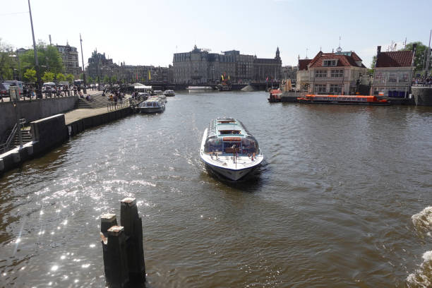 Amsterdam, the Netherlands, May 14, 2022 City canals with water. Ships are sailing on the river. old and modern buildings.