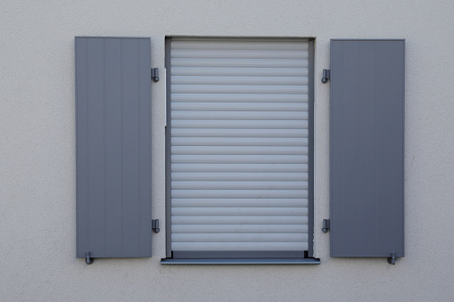 White wall with window, jalousie roll up, and blue wooden shutter 
are open, as a background no person,