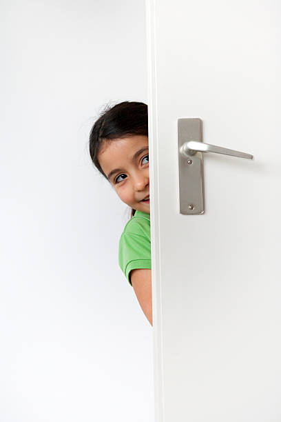 istock Little girl is hiding behind a door 139731015