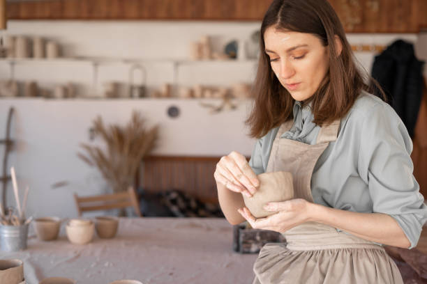 istock A young female master potter in the studio sculpts a clay pot. Banner. 1397311298