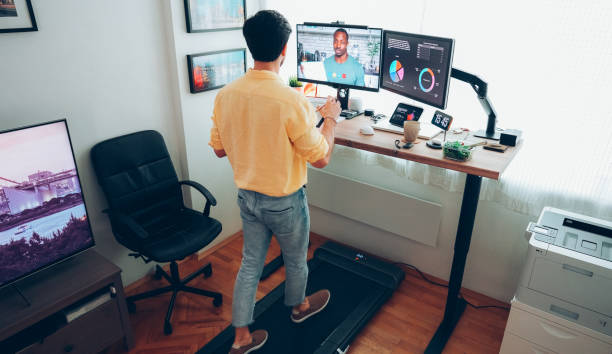 istock Man at standing desk home office talking on business video call 1397316703