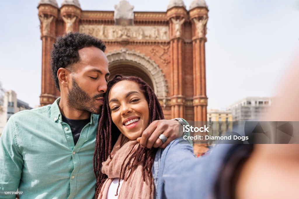 Happy hispanic latino couple dating outdoors Beautiful happy hispanic latino couple of lovers dating outdoors - Tourists in Barcelona having fun during summer vacation and visiting Arc de Triumf historic landmark 20-29 Years Stock Photo