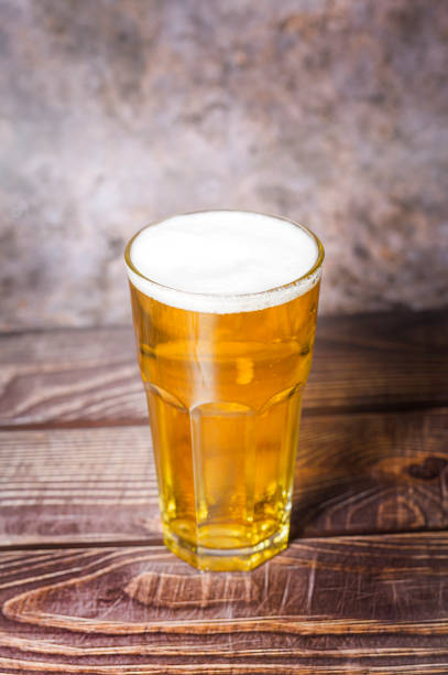 istock Cold craft  light Beer is pouring from bottle on wooden Table 1397318637