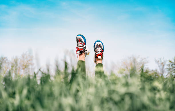 istock Person Lying In Tall Grass. Legs With Sneakers Pointed At Sky 1397320655