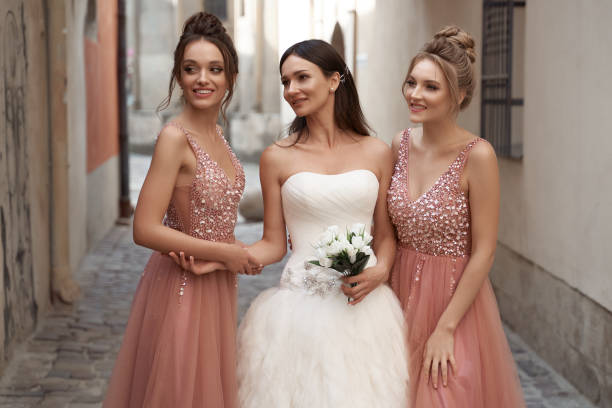 Beautiful bride and bridesmaids. Wedding day in old beautiful European city. stock photo