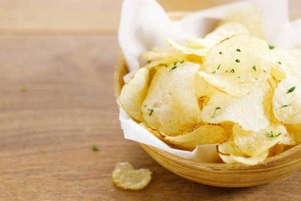 istock Crispy potato chips in wooden bowl 1397328533