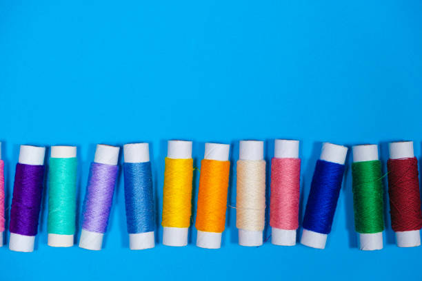 istock A set of multi-colored threads for sewing with an empty space for text on a blue background, top view. 1397330468